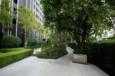 a walkway through a park with trees and a sign at Life Ladprao 2 bedrooms condo in Bangkok
