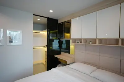 a bedroom with a bed and a desk and cabinets at Life Ladprao 2 bedrooms condo in Bangkok