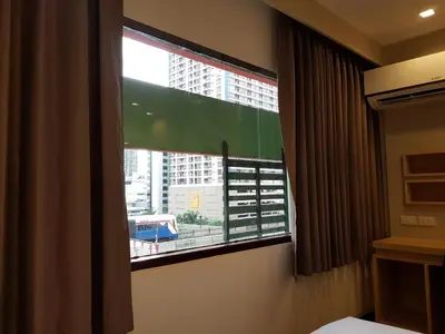 a bedroom with a window with a view of a building at Florida Hotel in Bangkok