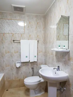 a bathroom with a white toilet and a sink at Florida Hotel in Bangkok