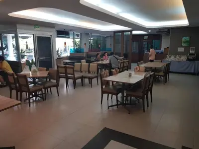 a restaurant with tables and chairs and people sitting at tables at Florida Hotel in Bangkok