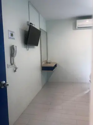 a room with a television on a wall with a tiled floor at The Seven Luck in Bangkok