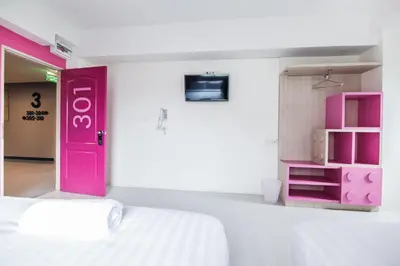 a room with a bed and a pink door at The Seven Luck in Bangkok