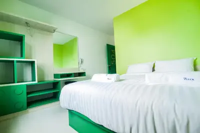 a bedroom with a large white bed and a television at The Seven Luck in Bangkok