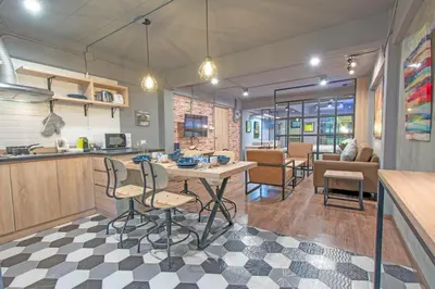 a kitchen and living room with a table and chairs at Private apartment in Huaikwang in Bangkok