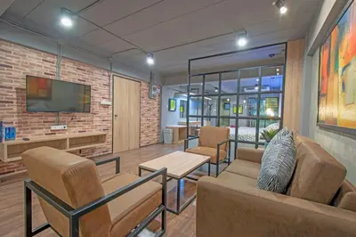 a living room with a couch and chairs and a tv at Private apartment in Huaikwang in Bangkok