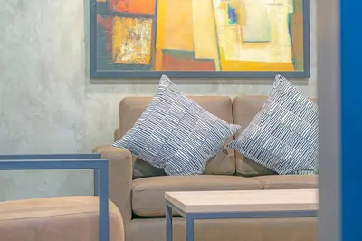 a painting of a couch with two pillows on it at Private apartment in Huaikwang in Bangkok