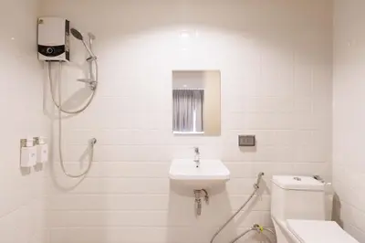 a bathroom with a shower and a sink and a toilet at Takka Hotel - Bearing in Bangna