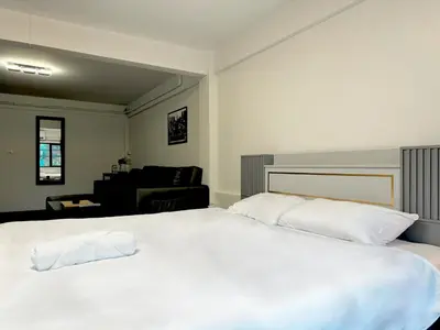 a bedroom with a large white bed with white pillows at Berlin Haus in Nonthaburi
