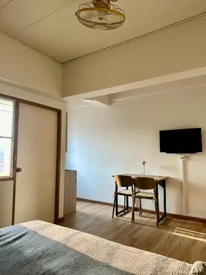a bedroom with a table and a tv on the wall at Sukkasame Apartment At Ngamwongwan in Ban Bang Khen (1)