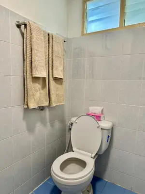 a bathroom with a toilet and a window and towels at Sukkasame Apartment At Ngamwongwan in Ban Bang Khen (1)