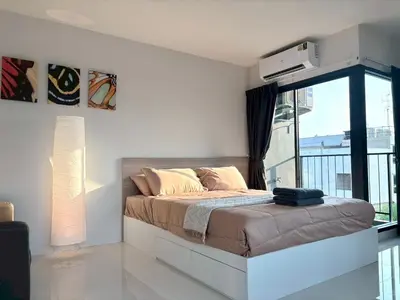 a bedroom with a bed and a large window at 4 mins to MRT Sutthisan in Bangkok