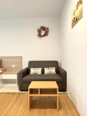 a living room with a couch and a coffee table at 4 mins to MRT Sutthisan in Bangkok