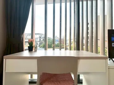 a table in front of a large window with a view at 4 mins to MRT Sutthisan in Bangkok