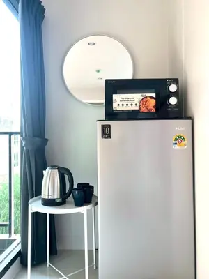 a white refrigerator with a microwave on top of it at 4 mins to MRT Sutthisan in Bangkok