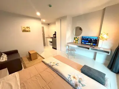 a living room with a couch and a desk with a television at 4 mins to MRT Sutthisan in Bangkok
