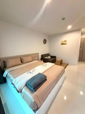 a bedroom with a large bed and a chair at 4 mins to MRT Sutthisan in Bangkok