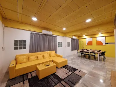 a living room with a yellow couch and a table at The Yellow House Poolvilla in Sathani Ban Hua Mak