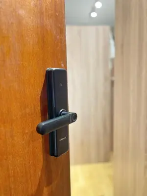 a black door handle on a wooden door at smoking buddy house in Bangkok