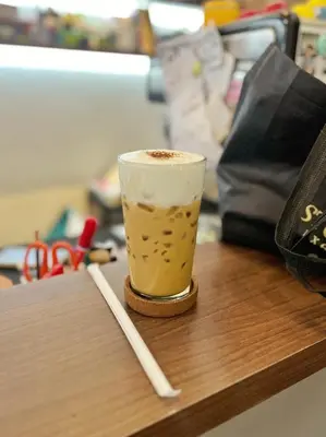 a cup of coffee sitting on top of a table at smoking buddy house in Bangkok