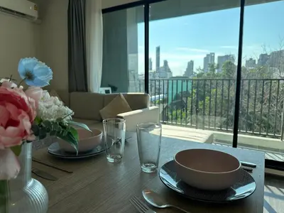 a dining room table with a view of a balcony at Chill Condo near Icon Siam in Bangkok
