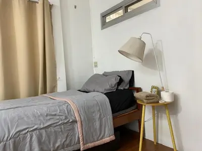 a bedroom with a bed and a table with a lamp at Cheap house 7min next to BTS Kasetsart , 5 bedroom in Ban Yang