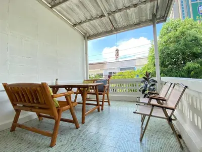 a patio with a table and chairs and a window at Cheap house 7min next to BTS Kasetsart , 5 bedroom in Ban Yang