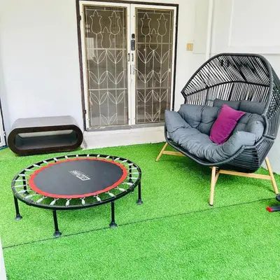 a chair and a table in a room with a carpet at Cheap house 7min next to BTS Kasetsart , 5 bedroom in Ban Yang