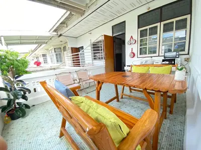 a dining room with a wooden table and chairs at Cheap house 7min next to BTS Kasetsart , 5 bedroom in Ban Yang