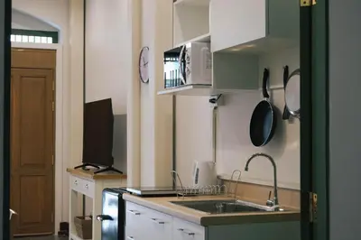 a small kitchen with a sink and a microwave at SuXiang - Chinatown, Bangkok in Bangkok