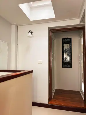 a hallway with a glass door and a mirror at SuXiang - Chinatown, Bangkok in Bangkok
