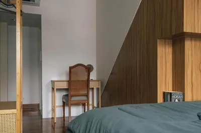 a bedroom with a bed and a desk and a chair at SuXiang - Chinatown, Bangkok in Bangkok