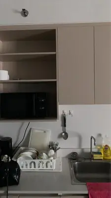 a kitchen counter with a sink and a microwave at Mari's space city view in Nonthaburi