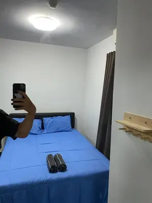 a person taking a picture of a bed with shoes on it at Mari's space city view in Nonthaburi