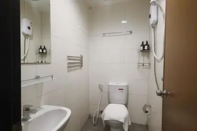 a white bathroom with a toilet and a sink at Sampheng House in Bangkok