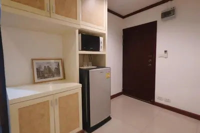 a kitchen with a refrigerator and a black door at Sampheng House in Bangkok