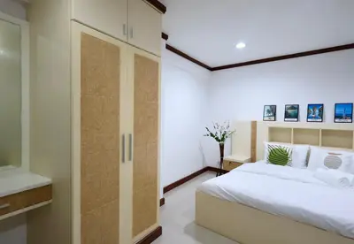 a bedroom with a white bed and a glass door at Sampheng House in Bangkok