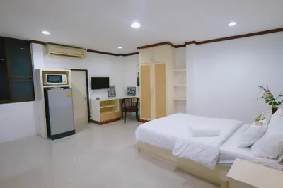 a bedroom with a bed and a microwave and a kitchen at Sampheng House in Bangkok