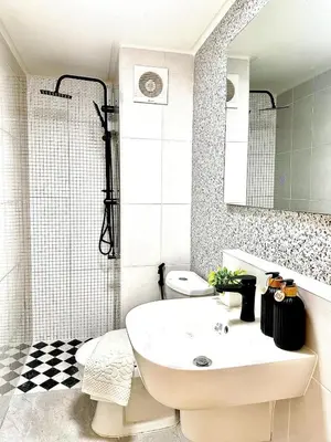 a white bathroom with a sink and a shower at CinCin Popular Condo in Thung Si Kan