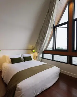 a bedroom with a large bed and a large window at Baan Manee BKK in Bangkok