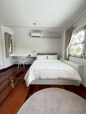 a bedroom with a bed and a desk and two windows at 5 beds private garden resort 452sqm Pet relax in Sathani Ban Hua Mak
