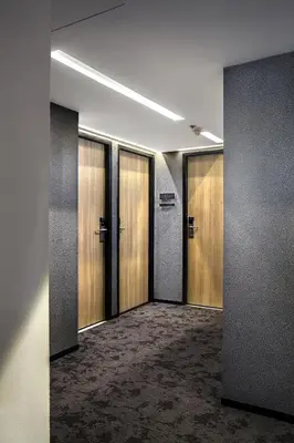 a hallway with wooden doors in a building at Galleria 12 Sukhumvit Bangkok by Compass Hospitality in Bangkok