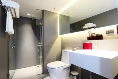 a bathroom with a toilet and a sink and a shower at Galleria 12 Sukhumvit Bangkok by Compass Hospitality in Bangkok