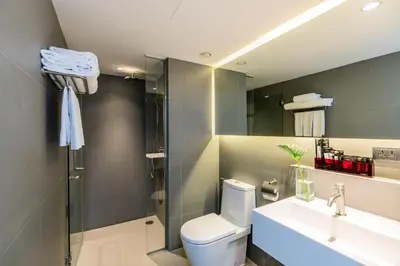 a bathroom with a toilet and a sink and a shower at Galleria 12 Sukhumvit Bangkok by Compass Hospitality in Bangkok