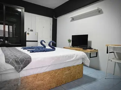 a bedroom with a bed with swans on it at Irich Residence Theparak S209 BTS-Chang Erawan 2kms in Ban Khlong Hua Sakae