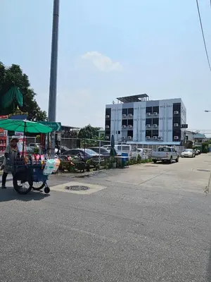 a person pushing a cart with a green umbrella at Irich Residence Theparak S209 BTS-Chang Erawan 2kms in Ban Khlong Hua Sakae