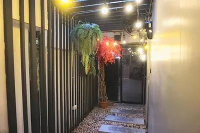 a hallway with a palm tree in a building at Hash Capsule Hostel Silom Soi 3 in Bangkok