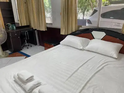 a bedroom with a large white bed with towels on it at Home Rama 4 near BTS Thong Lor in Khlong Toei