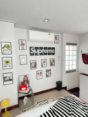 a bedroom with a white wall with pictures on it at Nueng Rana 113 Unique House in Chinatown 3BR 2BA - Villa in Samphanthawong