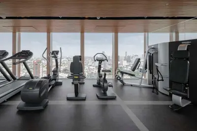 a gym with cardio equipment in a building with a view at \u7d20\u5764\u9038\u6cbf\u7ebfBTS Ekkama Station in Bangkok